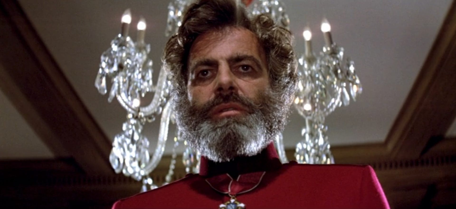 A bearded mad scientist looms in front of a chandelier in The Black Hole on Disney Plus