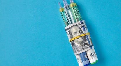 Insulin syringes wrapped in a hundred-dollar bill