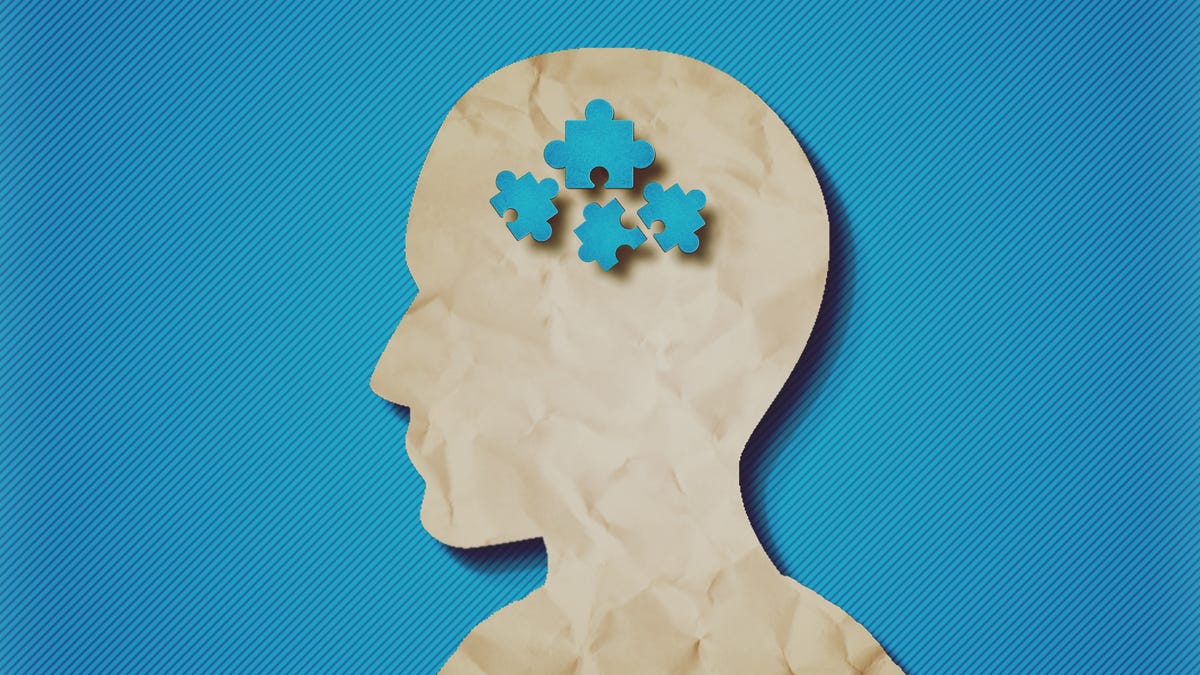 paper head with blue puzzle pieces, a common image used to signify autism