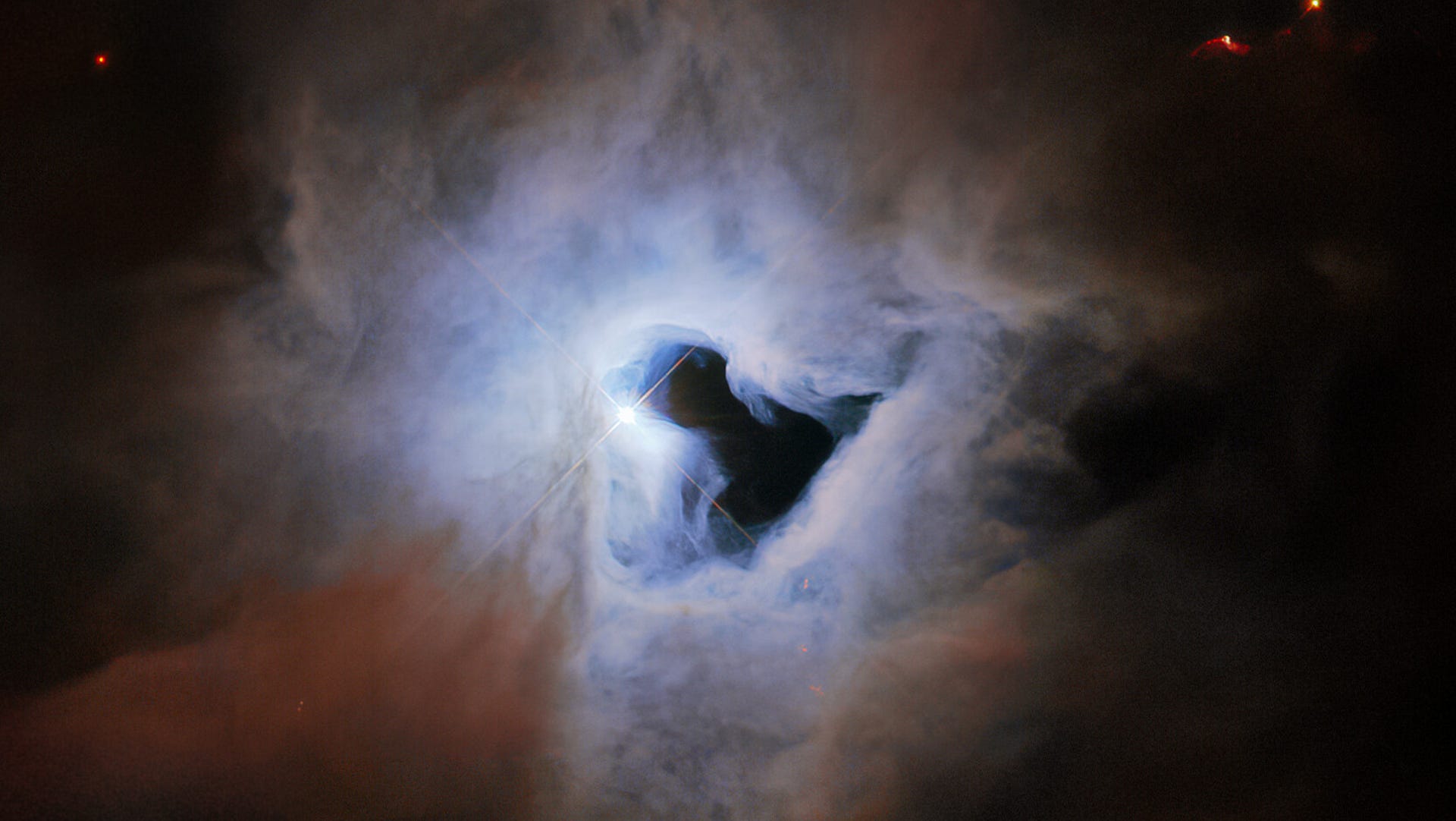 Ethereal view of a ghostly cloud with a dark, open spot in the center like a keyhole showing the dark of space behind.