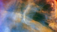Swirling nebula cloudscape with washed out colors in shades of blue, red and orange.