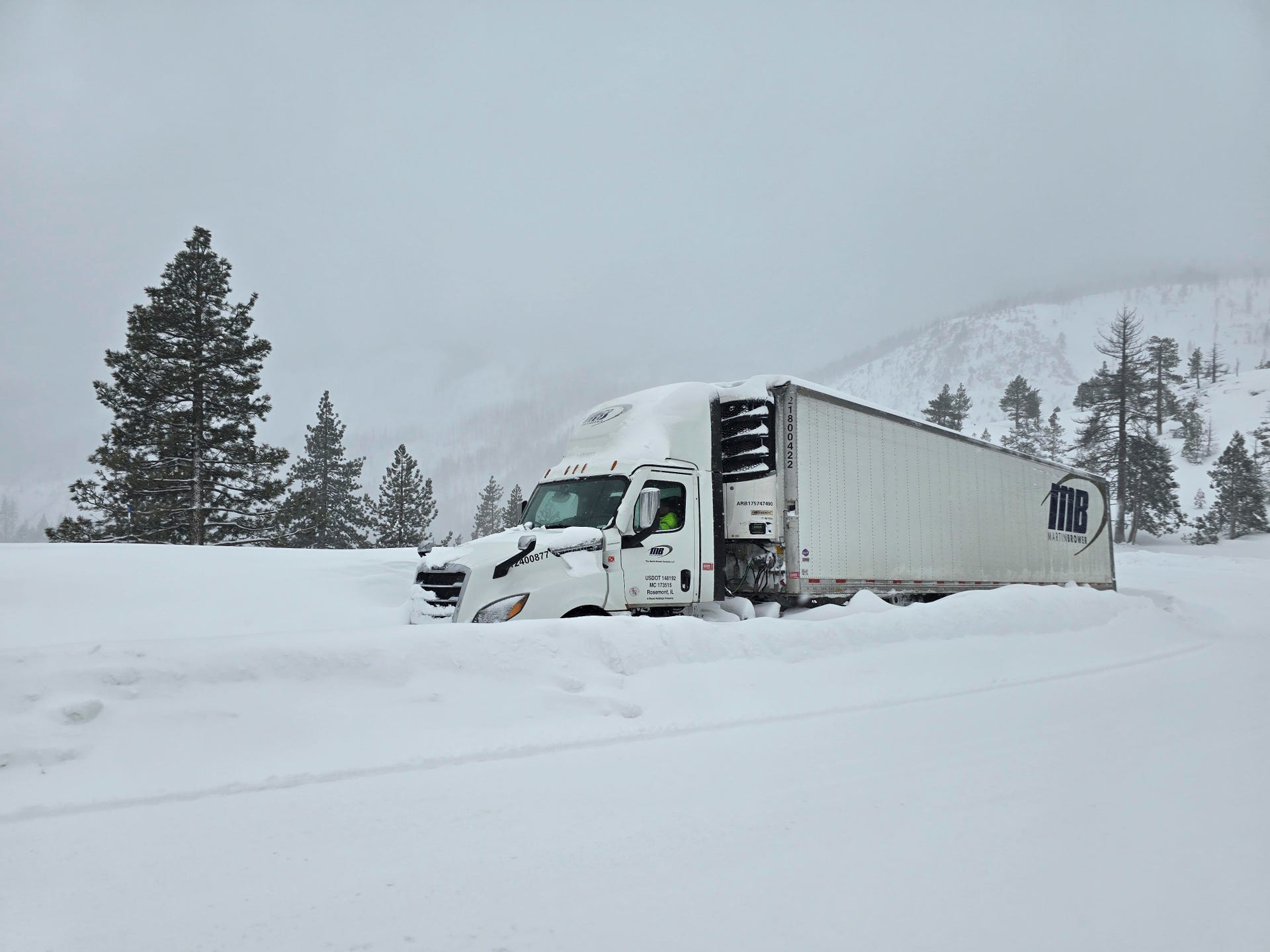 Snowed in tractor trailer truck on Interstate 80 as a blizzard shut down travel across the Sierra Nevada mountains