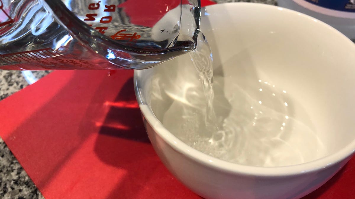 Pouring white vinegar into a meal-sized bowl.