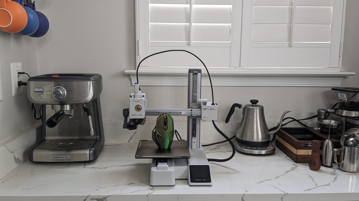 A 3D printer sat next to a kettle and a coffee machine