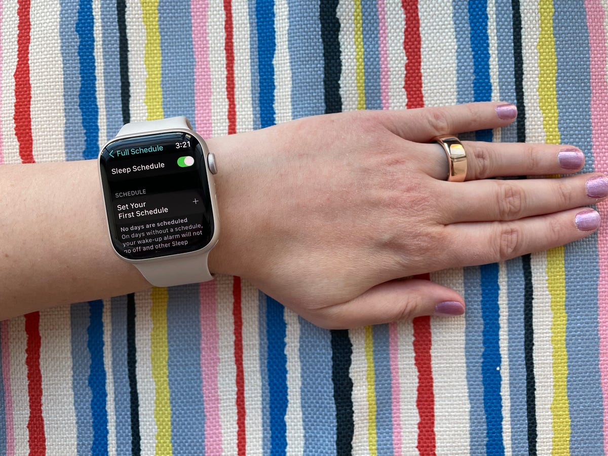 The Apple Watch and an Oura ring being worn