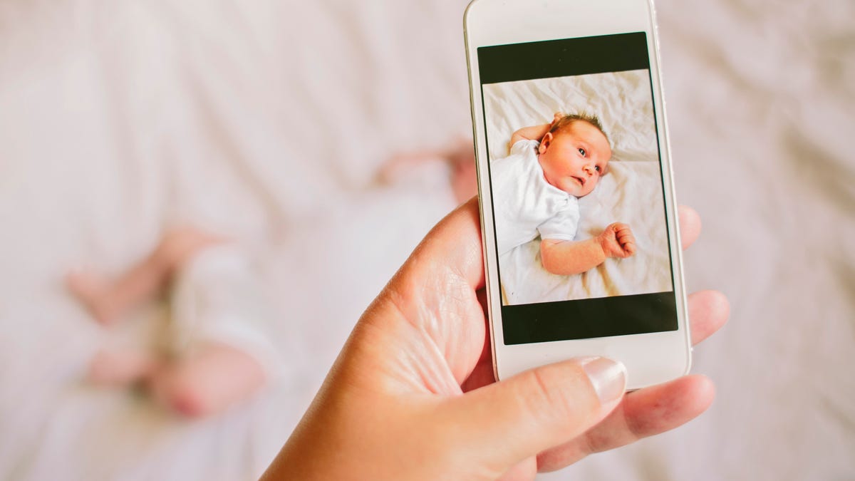 person taking smartphone photo of a baby
