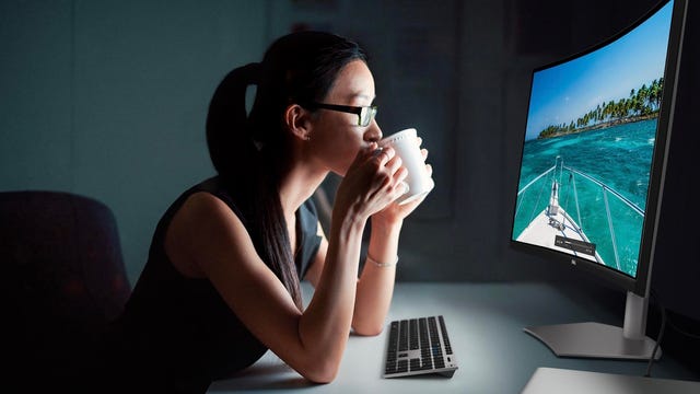 Dell S3221QS display in front of a woman drinking coffee or tea