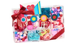 Clear box filled with colorful candy tied in a red bow.