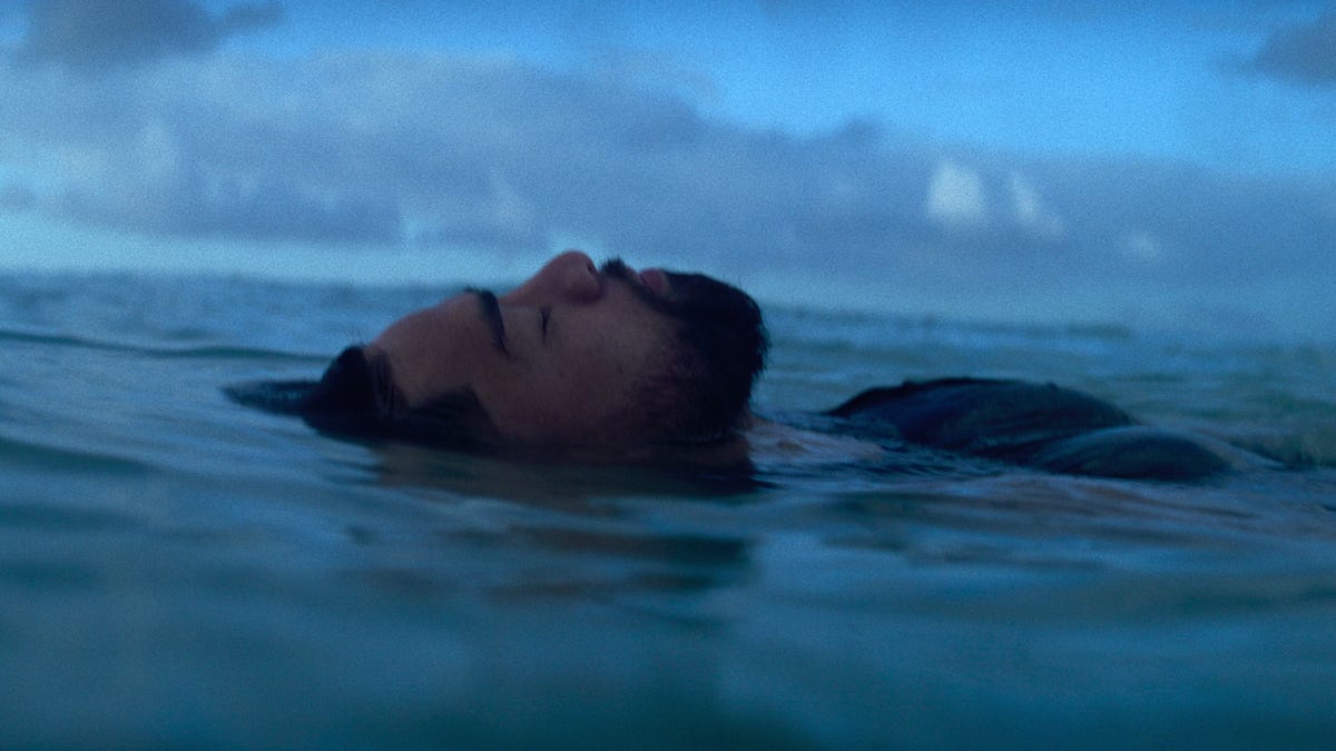 A man floating in the sea with his eyes closed