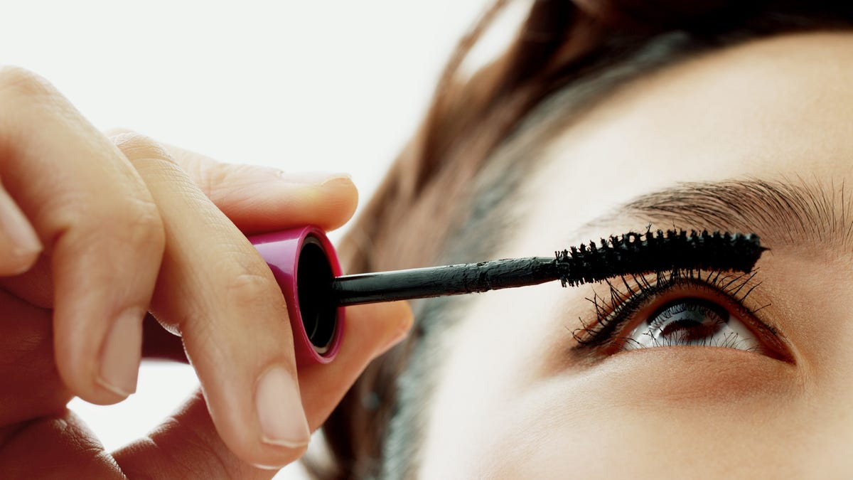 Person applying mascara to their eyelashes