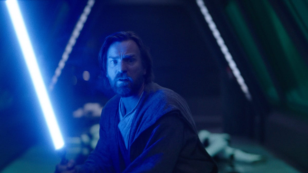 Obi-Wan Kenobi welds his blue lightsaber with defeated Stormtroopers in the background