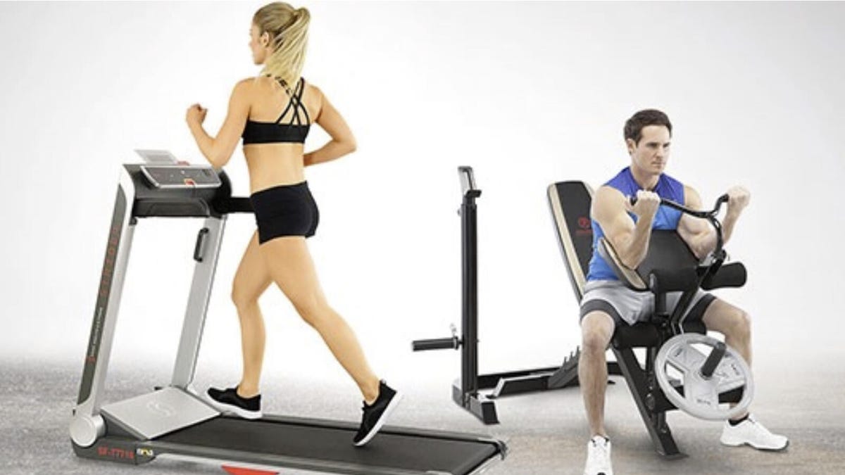 A woman runs on a treadmill and a man uses a leg developer and squat rack.