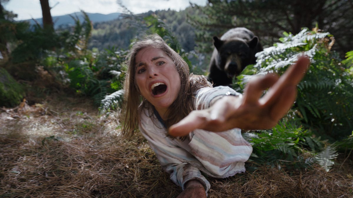 tech news A woman screams as she's chased by a bear in a scene from the movie Cocaine Bear.