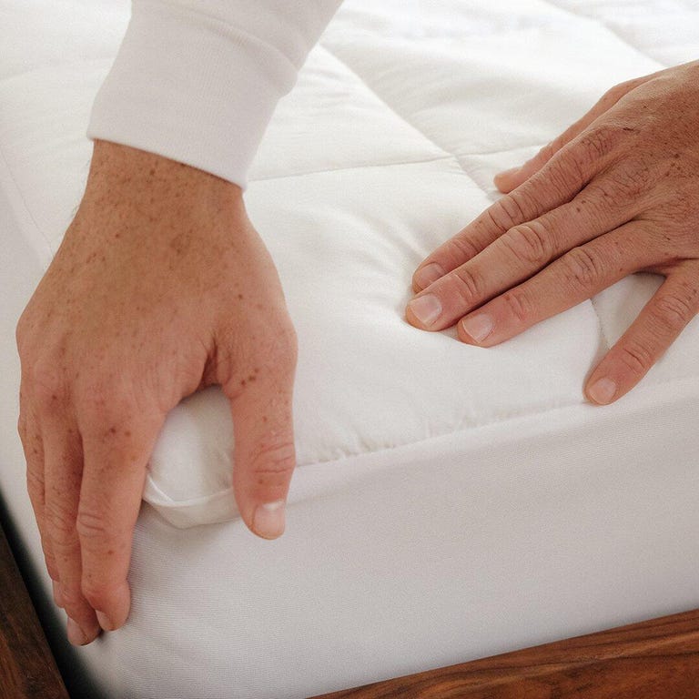 Hands on a mattress pad