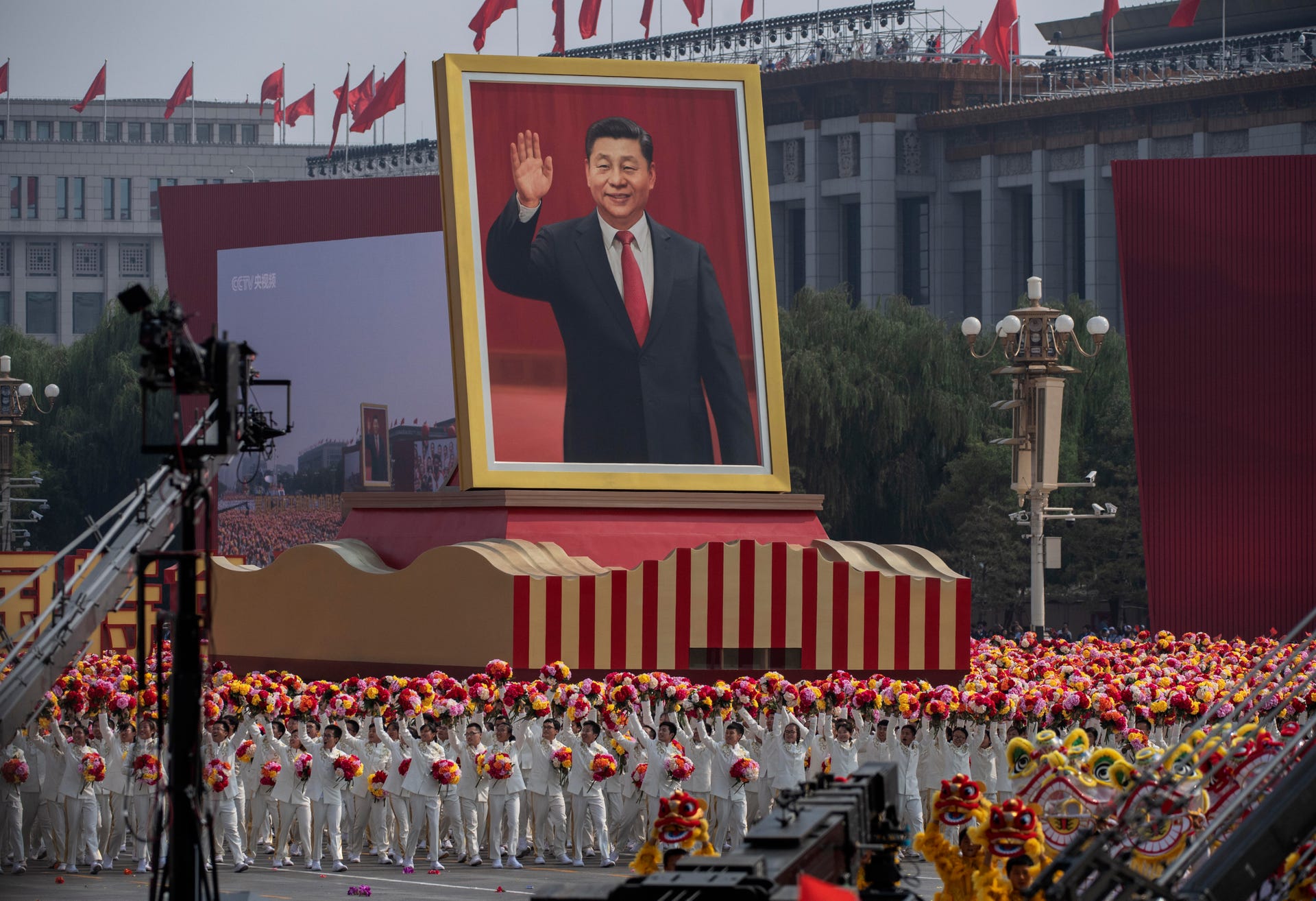 Billboard-sized portrait of Chinese President Xi Jinping at an outdoor ceremony.