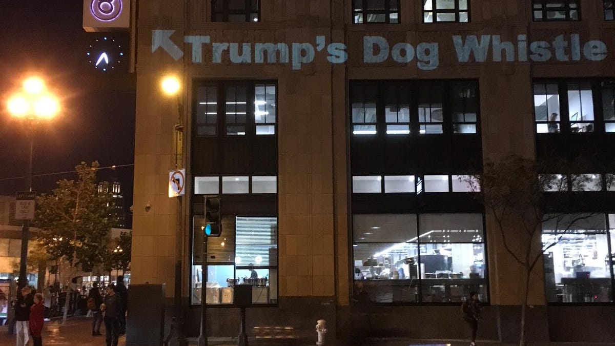 Activist Alan Marling projects a message -- "Trump's dog whistle" -- onto Twitter's headquarters building.