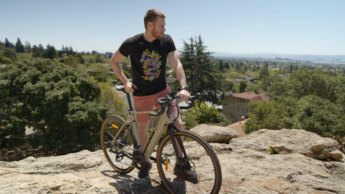 Man stands next to electric bike in the wilderness
