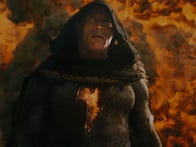 <p>Hooded Dwayne Johnson emerges from an explosion as Black Adam</p>