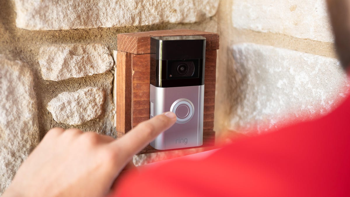 A Ring video doorbell mounted to a stone exterior wall.