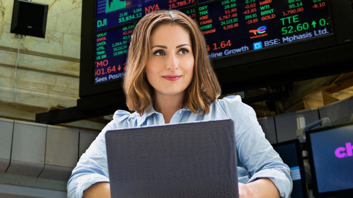 Farnoosh behind a laptop with a backdrop of the NYSE