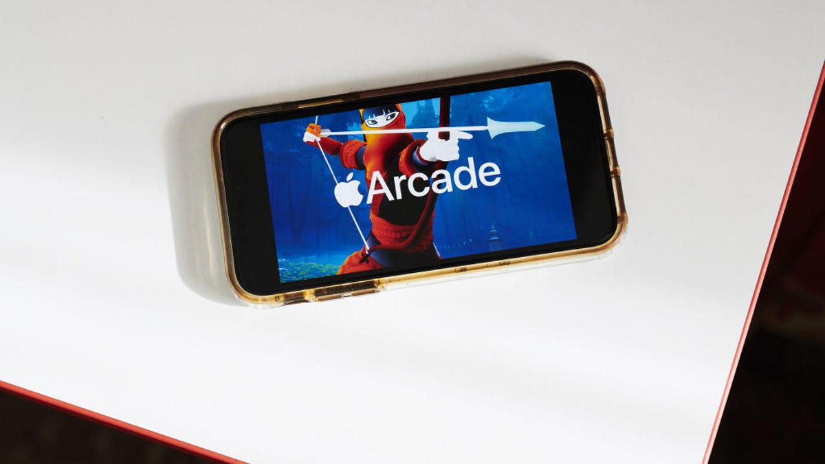 A smartphone with the Apple Arcade logo on the screen. A person with a bow and arrow is behind the logo