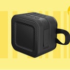 The Skullcandy Barricade mini Bluetooth speaker is displayed against a yellow background.