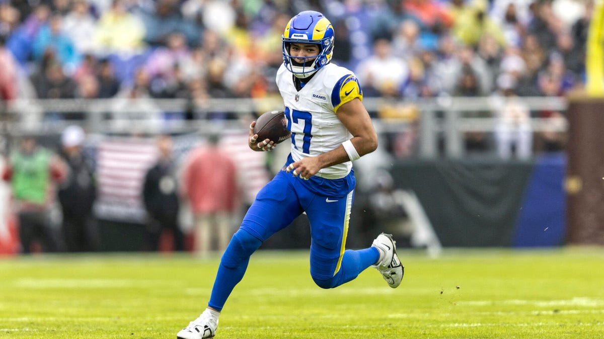 Puka Nacua of the Los Angeles Rams running with the ball under his right arm.