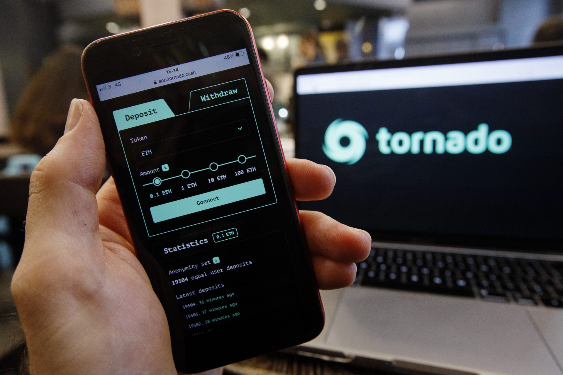 The Tornado Cash application on a phone, with the app's logo in the background.