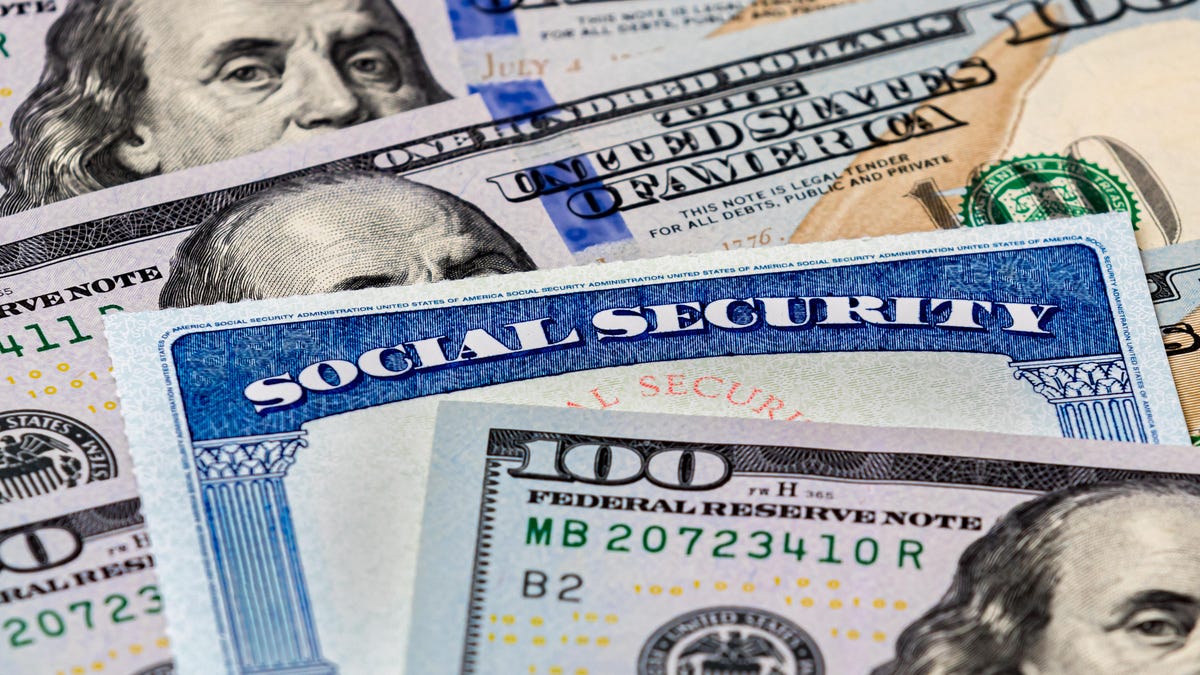 Social Security card on top of $100 bills