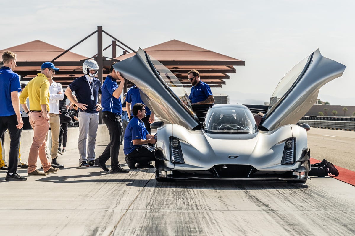 Front view of the Czinger 21C hypercar with doors open and people surrounding it