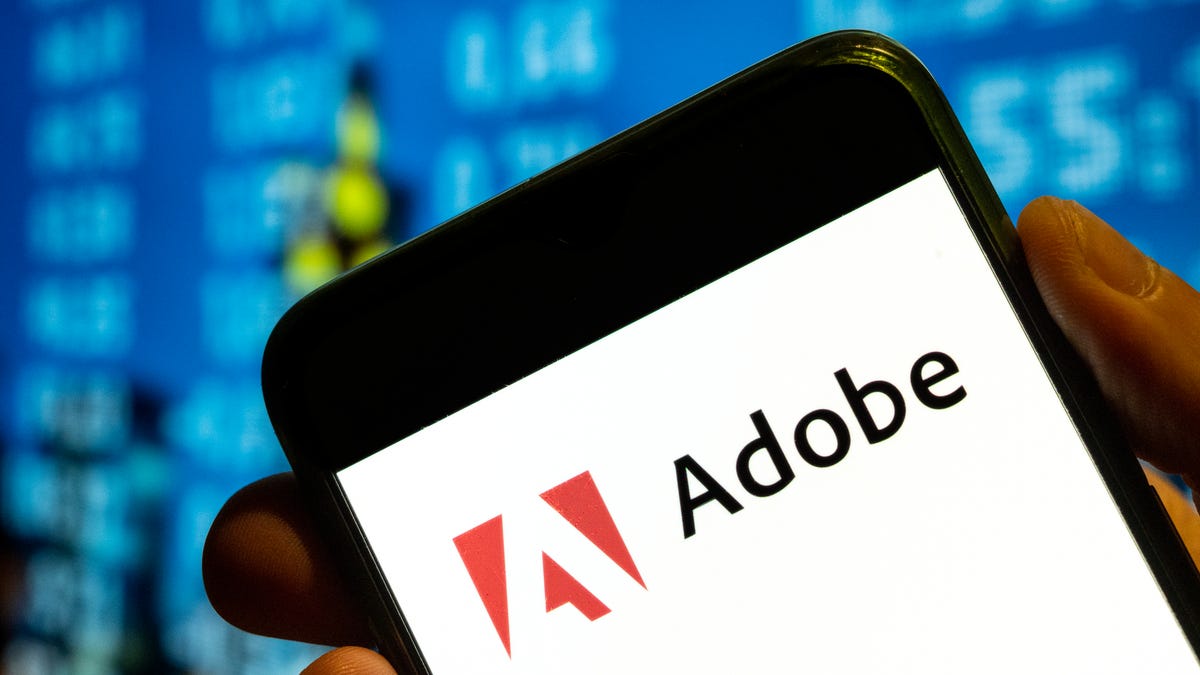 A phone with Adobe's logo on the screen, against a backdrop of white numbers on a blue screen