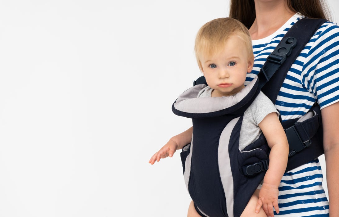 Parent wearing their baby via soft-structured carrier