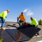 A solar panel install taking place on a roof