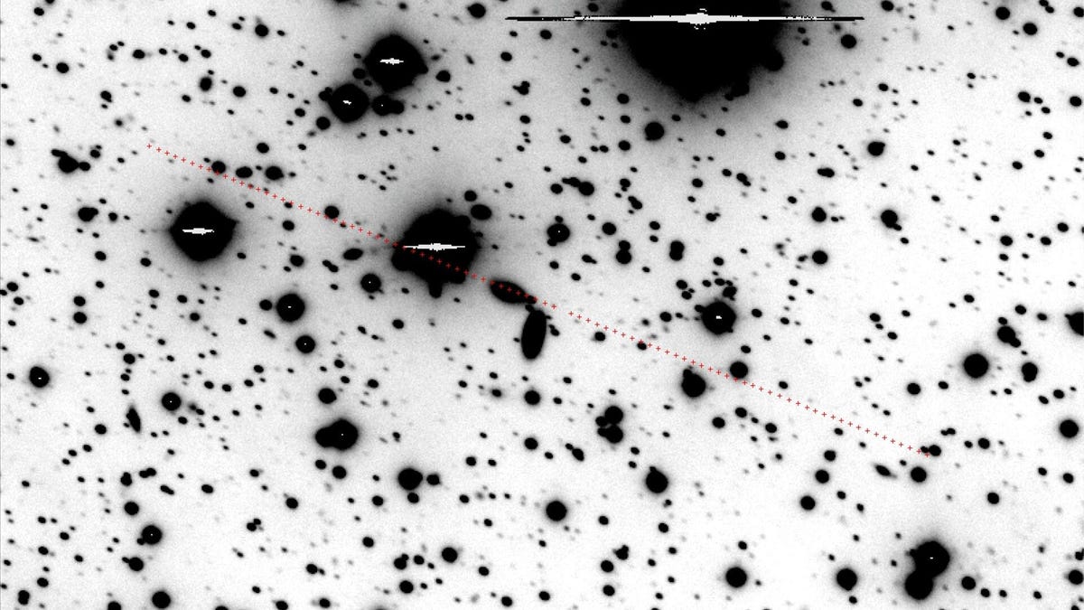 Black blotches against a white background indicate stars with a red line showing the path of the faint asteroid.