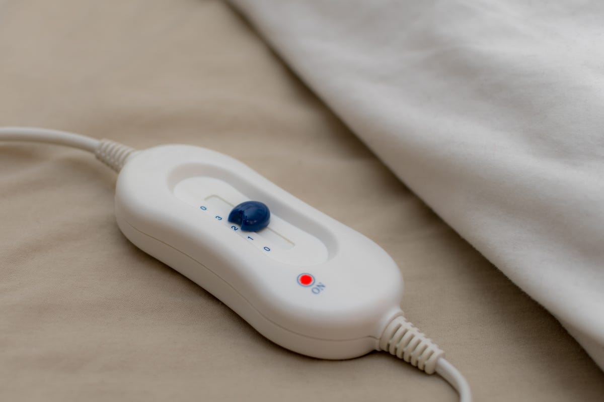 Control button for an electric blanket on a bed.
