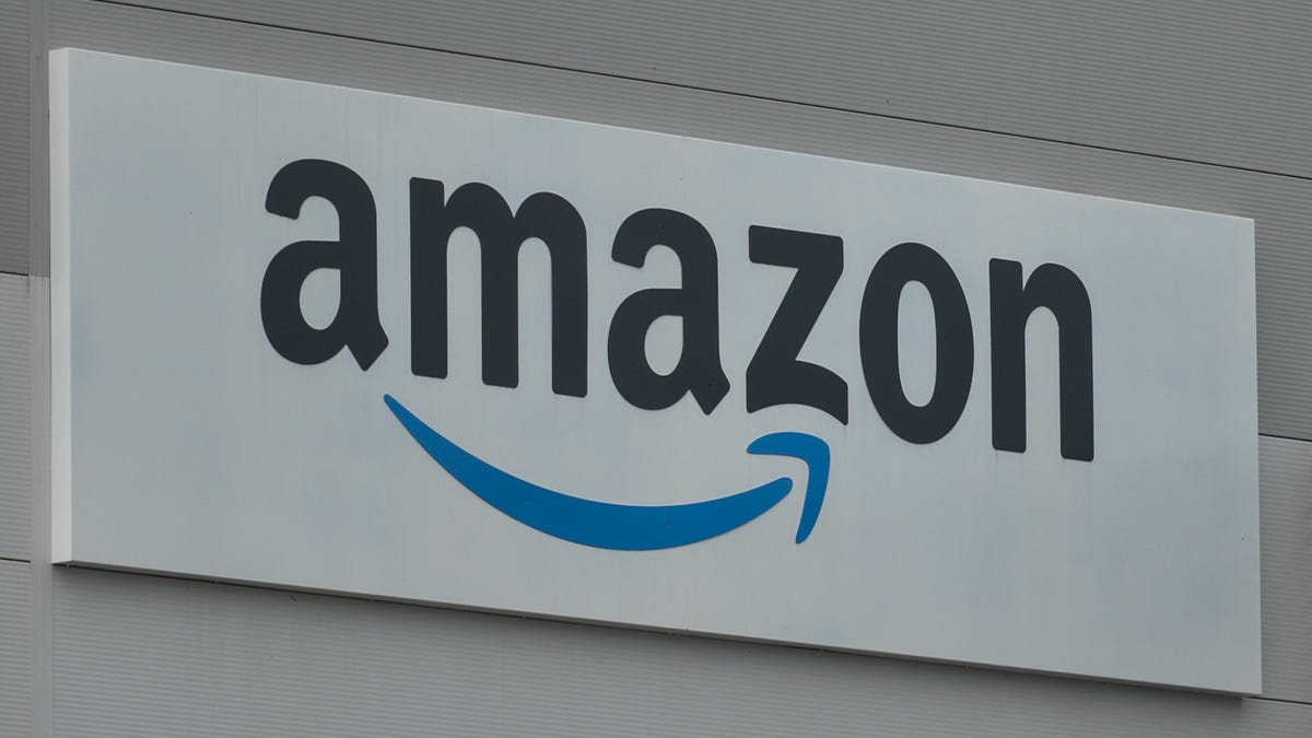 Close-up of an Amazon sign with the company's smile logo on the side of a warehouse.