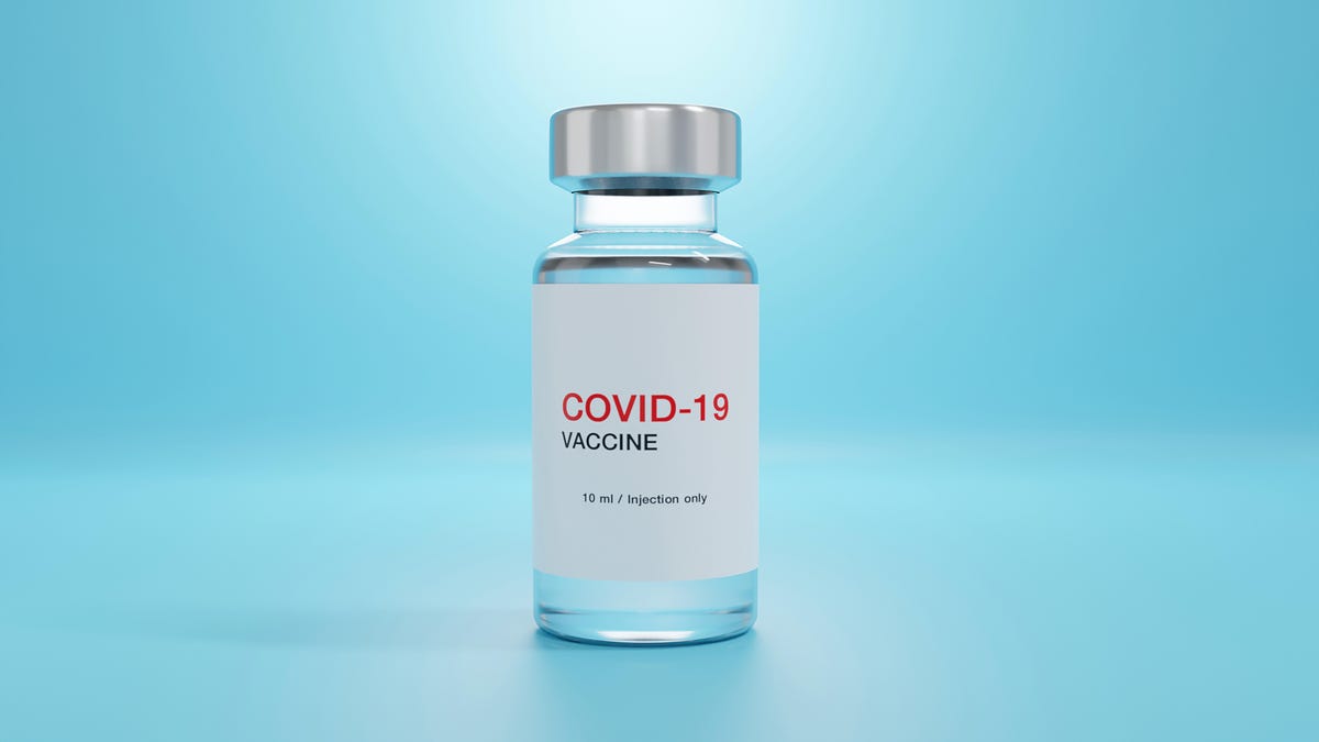 A vial of COVID-19 vaccine against a light blue background