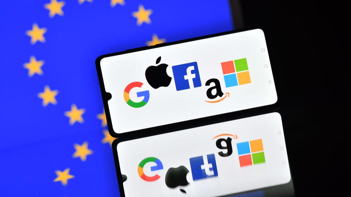 Logos of Google, Apple, Facebook, Amazon and Microsoft on a phone screen, with a backdrop of the EU flag.
