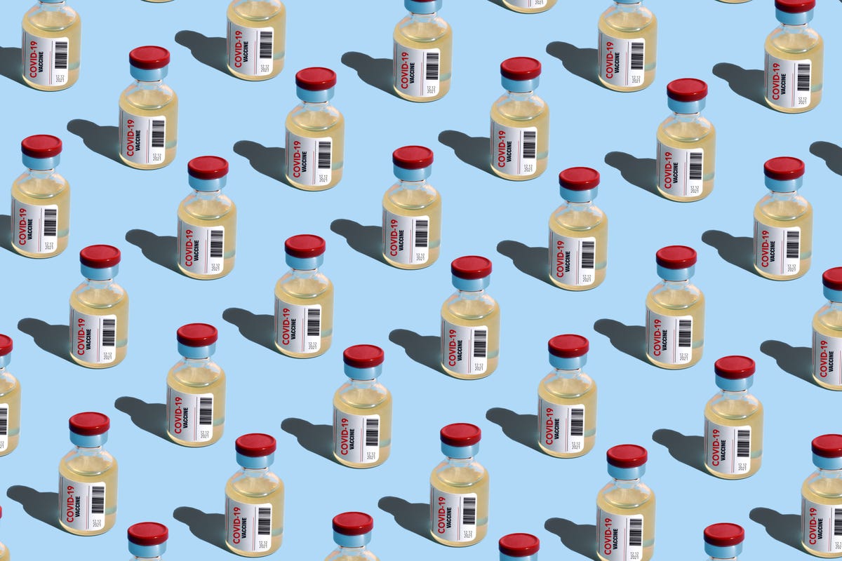 Vials of COVID vaccine lined arranged on a light blue background
