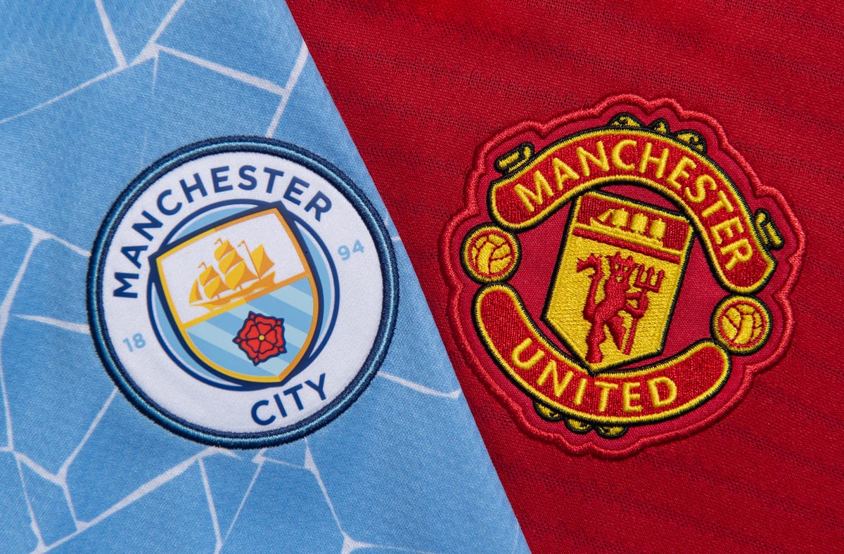 The club badges of Manchester City and Manchester United