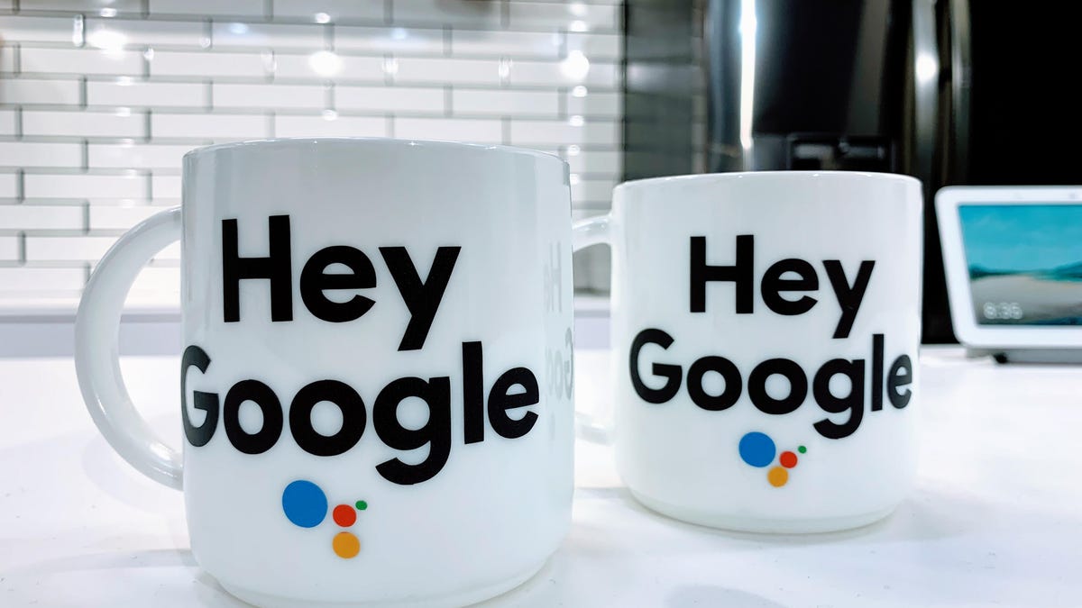 Two white coffee mugs that have "Hey Google" written on them