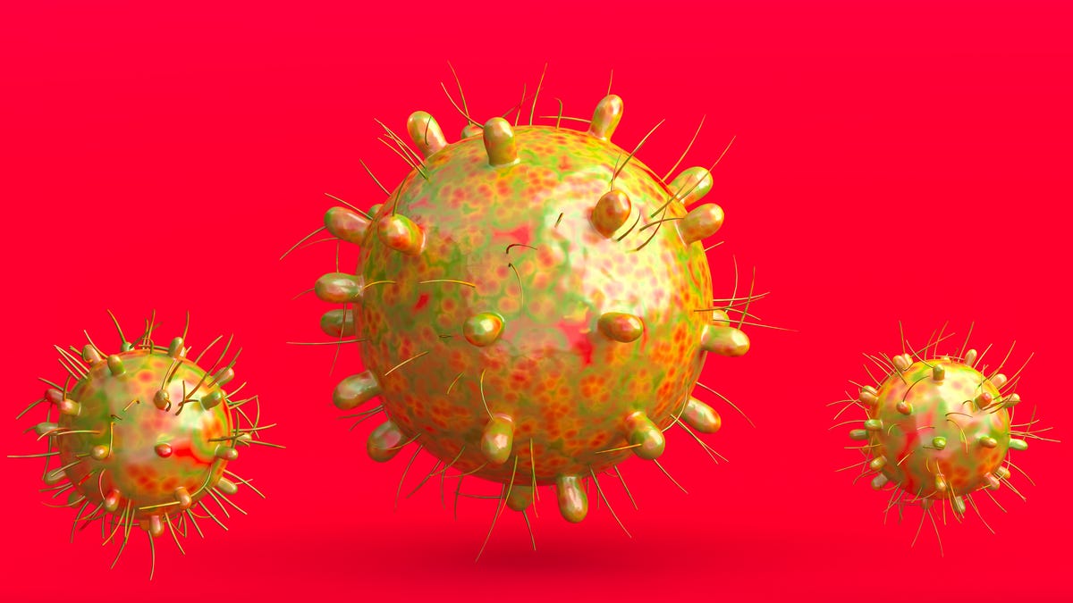 Spikey, yellow models of the coronavirus on a red background.
