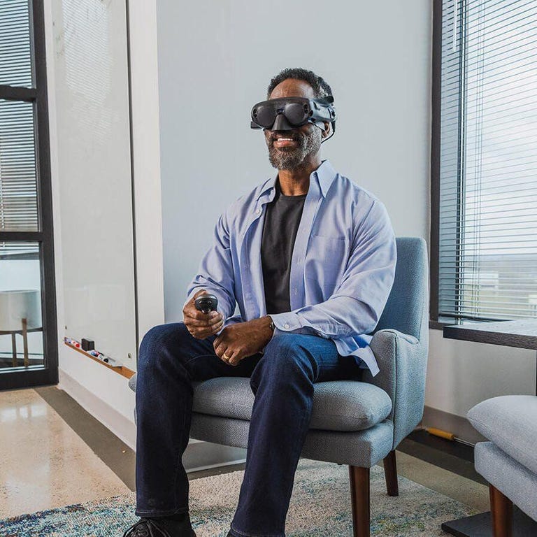 A man seated in a chair and wearing a VR headset