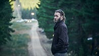 Joel Edgerton standing on a dirt road in a forest