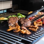 grill mat on grill with meats and veggies