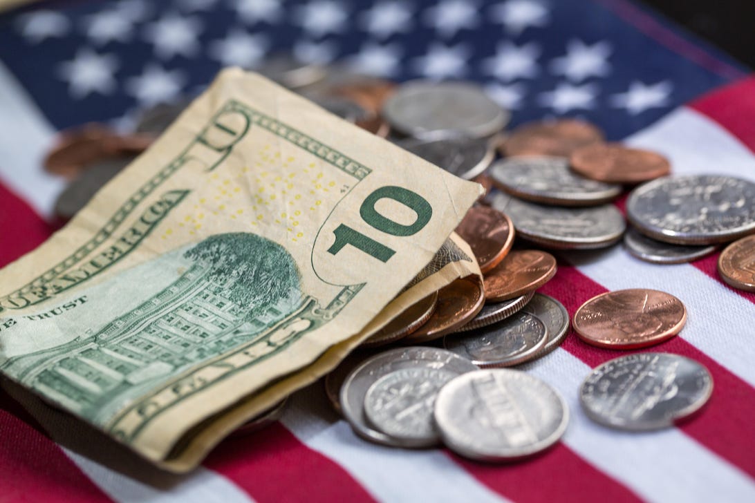 Some cash and coins on the American flag
