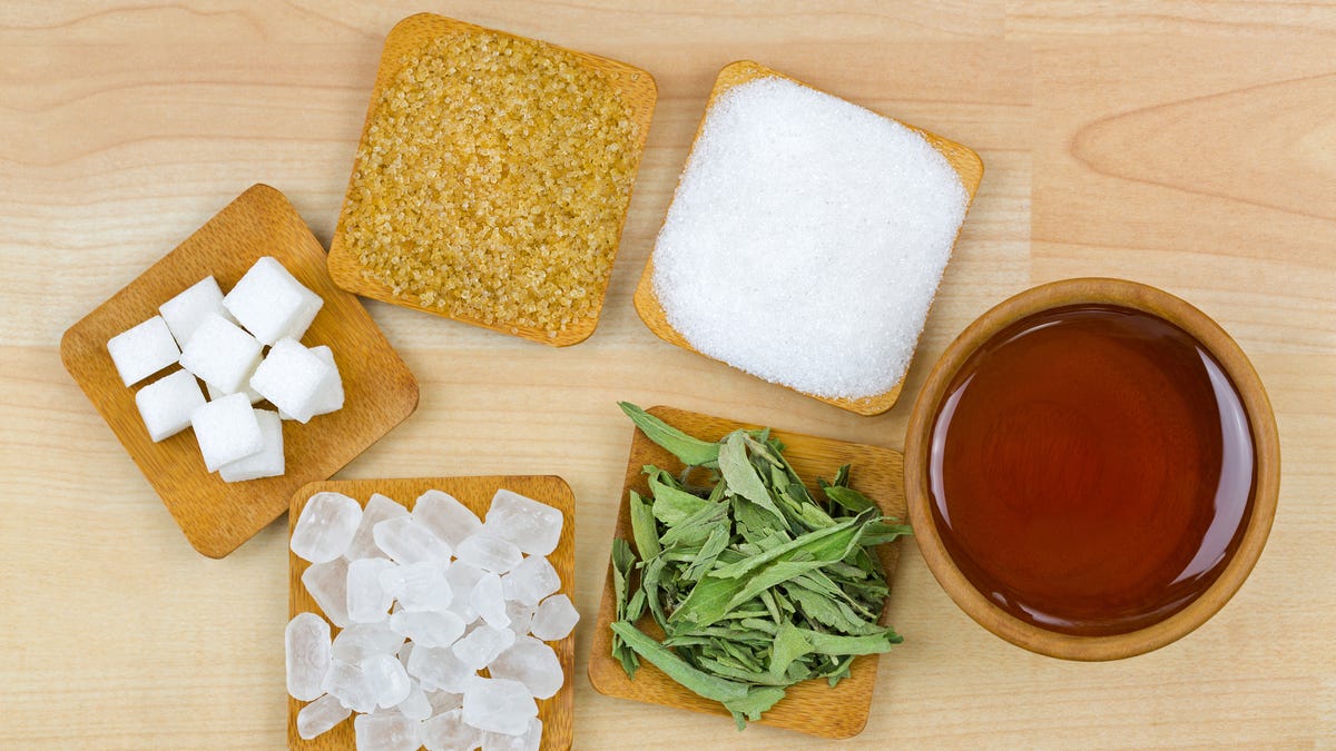 Sugar cubes, brown sugar crystals, granulated white sugar, rock sugar, stevia and honey. Different types of natural sweeteners.