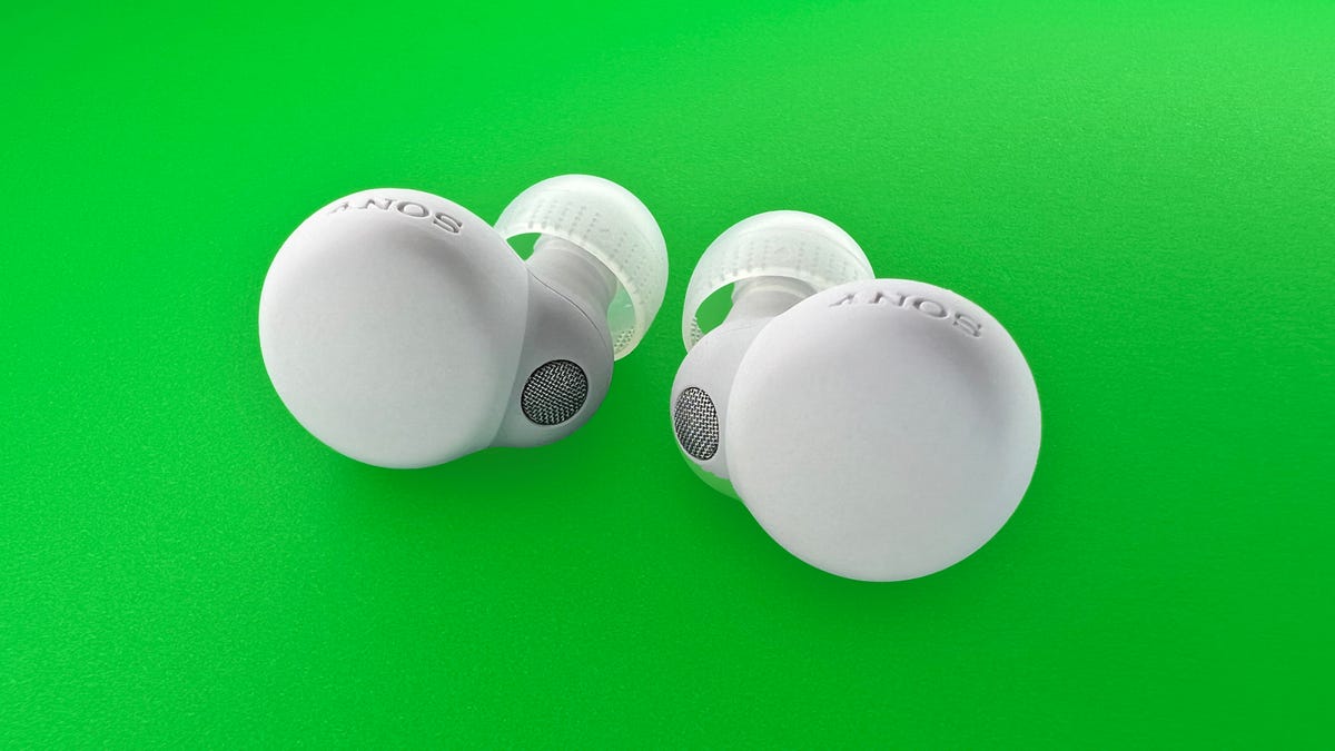 White Sony LinkBuds on a green background