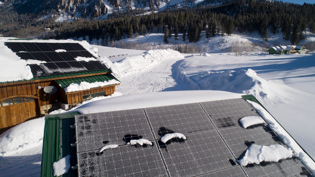 Snow melts off of rooftop solar panels in the mountains.