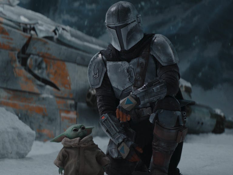The Mandalorian kneels in a snowy cave with 